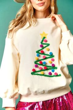 a woman wearing a christmas tree sweatshirt and sequin skirt