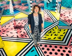 a woman standing in the middle of a colorful floor