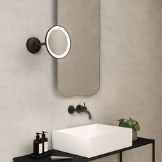 a bathroom with a sink, mirror and soap dispenser