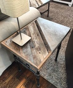 a coffee table made out of pallet wood with a laptop on it and a lamp next to it