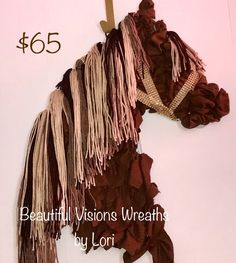 a horse made out of brown and pink fabric with the words beautiful visions wreaths by lori on it