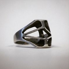 This is a handmade ring, sculpted in wax an cast in sterling silver by myself. The silver is blackened, then brought to a polish on the two areas in the front. This abstract piece is inspired by masks, bones, and skull shapes, though not a specific reference to anything in particular.  Item is made to order. Please allow two weeks for production or contact me to check availability if you need it sooner. Modernist Hand Cast Sterling Silver Rings, Bone Mask, Wax Ring, Bone Ring, Spike Necklace, Stainless Steel Jewelry, Ceramic Painting, Sterling Ring, Handmade Ring