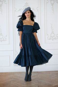 Capture the enchantment of rural France in this high-waist midi dress, boasting a pleated puff skirt and a playfully ruffled hem. Crafted with bows at the sleeve and waistline, and complete with pockets, it's the perfect attire for gathering fresh orchard apples and enjoying wine tasting in the countryside. Pair with the Farmhouse Tartan Duchess Corset to complete the look. Paper cotton midi dress with puff sleeves Double layer pleated puff skirt and ruffled hem Side seam pockets Bow tie detail Christmas Midi Dress, Witchy Wardrobe, Rural France, Puff Skirt, Skirt Swimsuit, Market Dress, Puff Dress, The Farmhouse, Cotton Midi Dress