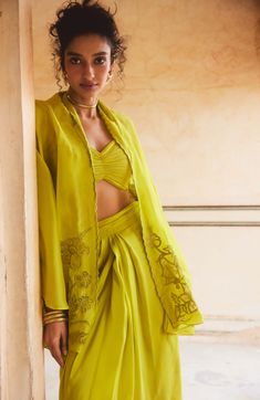 Introducing a breezy and romantic fresh lemon yellow cape set, crafted from pure silk organza fabric for a luxurious feel. This set showcases beautiful scallop and cutwork details, adding an elegant touch to the ensemble. The blouse features draped gathering details, while the pleated pre-draped skirt completes the look with effortless charm. Ideal for adding a touch of sophistication to any occasion. Summer Sets In Organza With Traditional Drape, Traditional Drape Organza Sets For Summer, Summer Wedding Sets With Cape Sleeves, Draped Silk Sets For Summer, Elegant Yellow Palazzo Set With Traditional Drape, Yellow Organza Sets With Chikankari Embroidery, Yellow Silk Set For Summer, Silk Yellow Sets With Sheer Dupatta, Yellow Festive Sets With Cape Sleeves