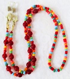 Red/Multicolor Beaded Eyeglass Chain 25.5" in length, made with glass beads, beading cord, metal lobster clasps, and adjustable rubber holders. Lobster clasps make it easy to change the rubber holders, and an extra pair of holders are included with every purchase. This bold Red/Multicolor Beaded Eyeglass Chain will arrive in a gift box, ready to give as a present or to keep and store. Back to Beaded Eyeglass Chains Everyday Round Beaded Necklaces With Lobster Clasp, Red Adjustable Necklaces With Lobster Clasp, Multicolor Beaded Necklace With Lobster Clasp For Everyday Use, Red Adjustable Necklace With Lobster Clasp, Adjustable Red Necklace With Lobster Clasp, Adjustable Colorful Beaded Jewelry For Everyday Use, Adjustable Red Beaded Necklace With Lobster Clasp, Adjustable Beaded Chain Necklace For Everyday, Adjustable Round Beaded Necklaces For Everyday