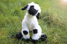 a black and white stuffed animal sitting in the grass