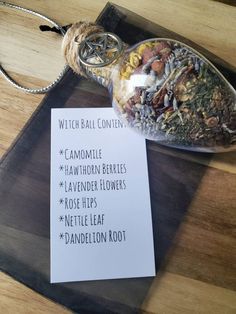 a glass bottle filled with lots of food on top of a wooden table next to a paper