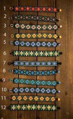 a number of bracelets on a wooden surface with numbers in the middle and two rows