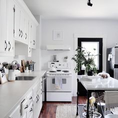 a white stove top oven sitting inside of a kitchen next to a sink and window