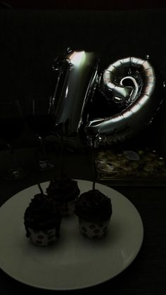 two cupcakes on a plate with an inflatable balloon