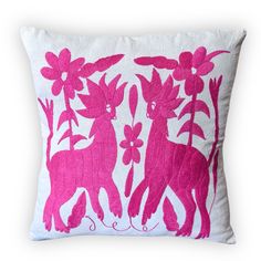 a pink and white decorative pillow with deers on it's sides, surrounded by flowers