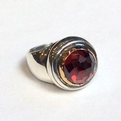 Strawberry red This is a chunky ring with a beautiful red garnet set in a gold bezel on top of a sterling silver band. Garnet is a hard, brilliant stone. It occurs in certain shades of red that have been taken for some varieties of ruby. (R2351). © 2011-2015, Artisanimpact Inc. All rights reserved. Construction & Dimensions: Sterling silver, 10k yellow gold, garnet. Approximate diameter on top: 16mm (0.62in). please indicate your size in the order. About our jewelry Artisanlook offers an exc Luxury Red Ruby Ring, Formal Red Birthstone Ring With Polished Finish, Formal Red Polished Birthstone Ring, Red Garnet Signet Ring For Anniversary, Classic Red Garnet Signet Ring, Red Garnet Rings With Polished Finish, Hallmarked Red Garnet Birthstone Ring, Red Gemstone Dome Ring, Red Birthstone Ring With Polished Finish For Anniversary