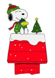 a snoopy dog sitting on top of a christmas cake with a tree in the background