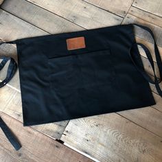 a black bag sitting on top of a wooden floor next to a pair of scissors