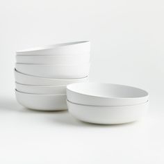 four white bowls stacked on top of each other in front of a white background,