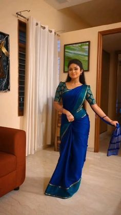 a woman in a blue sari posing for the camera with her hand on her hip