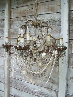 an old chandelier hanging from the side of a building with beads and pearls