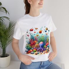 "Dive into the beauty of the ocean with our watercolor underwater life unisex t-shirt. This tee features a stunning depiction of vibrant coral reefs and a variety of playful fish, bringing the wonder of the sea to your wardrobe. Perfect for ocean enthusiasts and anyone who appreciates unique, artistic apparel. Made with comfortable materials, this shirt is ideal for everyday wear or as a special gift. Embrace the charm of the deep sea with this one-of-a-kind ocean-themed t-shirt! We utilize the Fish Shirt Design, Watercolor Coral Reef, Fall Board, Underwater Painting, Fish Shirt, Coral Watercolor, Underwater Life, Artist Outfit, Coral Reefs