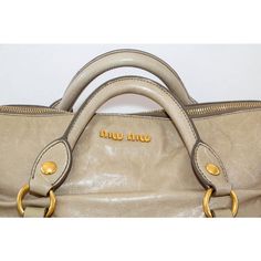 Miu Miu Beige Vitello Lux Leather Bow Handle Bag Satchel Tote. This handle bag from Miu Miu boasts a highly fashionable look. Made from Vitello Lux leather, this handbag features bows on each end with a top zipper closure that reveals a roomy interior. Lined with fabric and accented with gold-tone hardware, this bag makes a stylish pick for off-duty looks.  The tote has two handles, a shoulder strap, and a spacious fabric interior. This satchel from the house of Miu Miu is both stylish and durab Designer Satchel With Round Handle, Leather Bow, Satchel Tote, Leather Bows, Outfit Goals, Handle Bag, Hand Bag, Leather Top, Miu Miu