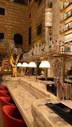 a bar with red chairs and marble counter tops