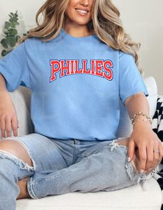 Are you in your Phillies Era? We are! Stay warm until the Phillies action heats up in this 50/50 blend soft and comfy Phillies Skyline and baseball t shirt with chenille baseball. Rock your Phillies pride wearing your red, white, and blue jawn! You'll love the cut and comfort of our tees! They are made of a 50/50 blend for the ultimate in softness! All items are unisex, giving a roomy fit. Create your Cute by adding a chenille or varsity letter patch to elevate your look! Our professional grade Pride Wear, Varsity Letter, Baseball T, Red Tee, Blue Tee, Philadelphia Phillies, Carolina Blue, Baseball T Shirt, Red White And Blue