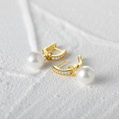 Indulge in the allure of these classic pearl earrings, as they effortlessly elevate any outfit with their refined beauty. These exquisite earrings feature detachable pearl pendants, allowing you to customize your look effortlessly. The hoops are adorned with sparkling white stones, adding a touch of brilliance to your ensemble. Whether worn as a sophisticated statement piece or as a delicate accessory, these earrings are sure to captivate attention and enhance your natural elegance. Embrace the Classic White Pearl Earrings For Everyday Elegance, Elegant Dangle Hoop Earrings With Pearl Drop, Elegant Dangle Pearl Drop Hoop Earrings, Elegant Pearl Drop Dangle Hoop Earrings, Elegant Pearl Hoop Earrings For Anniversary, Elegant White Hoop Earrings With Pearl Chain, Classic Elegant Design Pearl Earrings, Classic Elegant Pearl Earrings, Classic Pearl White Hoop Earrings