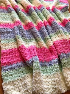 a crocheted blanket sitting on top of a wooden table