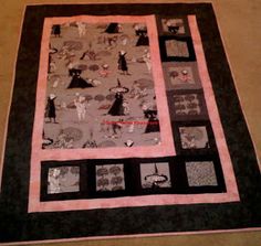 a black and pink quilt with pictures on it