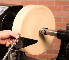 a person working on a machine with a large piece of paper in front of him