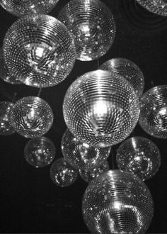 chandeliers hanging from the ceiling in a black and white photo, with lights reflecting off them