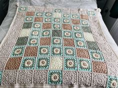 a crocheted blanket on top of a bed