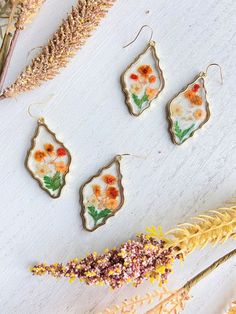 Pressed Wild Flower Earrings Multi Flower Earrings Resin | Etsy Gold Flower Earrings, Nature-inspired, Bohemian Drop Earrings With Pressed Flowers, Nature-inspired Gold Flower Earrings, Bohemian Pressed Flowers Drop Earrings, Nature-inspired Gold Flower Earrings With Charm, Nature-inspired Gold Earrings With Flower Charm, Bohemian Dangle Earrings With Pressed Flowers, Gold Nature-inspired Earrings With Flower Charm, Gold Flower-shaped Earrings With Pressed Flowers