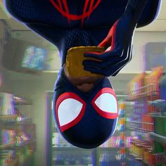 a spider - man character hanging upside down in the air with his hands on his hips