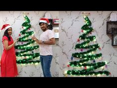 two people standing next to each other near a christmas tree