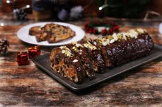 some food is sitting on a black plate near other plates and christmas decorations in the background