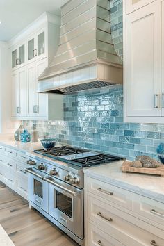 a stove top oven sitting inside of a kitchen next to white cabinets and counter tops