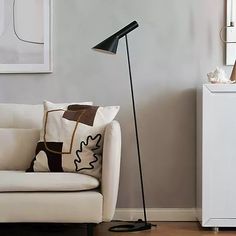 a living room with a white couch and black floor lamp