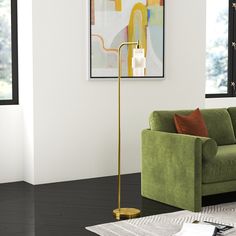 a living room with a green couch and a gold floor lamp in the middle of it