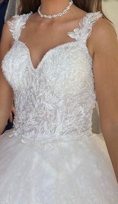 a woman in a white wedding dress is posing for the camera