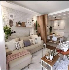 a living room filled with lots of furniture next to a white brick wall covered in plants