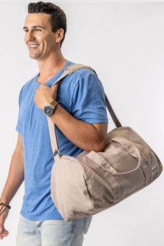 a man holding a bag and smiling at the camera