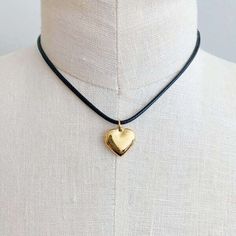 This Black Cord Heart Drop Necklace is a timeless addition to your jewelry collection. Featuring a fashionable black cord chain and dimensional rounded heart pendant, this necklace will be the perfect accent to any outfit. With its versatility and class, it's sure to impress. Material Composition: 18k gold plated stainless steel, water and tarnish free Lead and Nickel free Imported Adjustable Metal Heart Pendant Charm Necklace, Adjustable Heart Charm Necklace With Round Pendant, Valentine's Day Heart Pendant Necklace With Adjustable Cord, Gold Drop Necklace, Drop Necklace, Steel Water, Heart Pendant, Jewelry Collection, 18k Gold