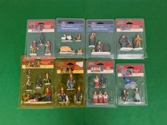 six plastic figurines are in the package on a green tablecloth with white writing