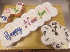 three decorated birthday cupcakes sitting on top of a yellow tray next to each other