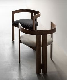 a wooden chair with a black cushion on it's back and armrests