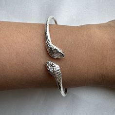 Crafted from solid .925 sterling silver, this Snake Bangle embodies transformation and eternal elegance— honored symbols. A perfect symbol of rebirth and divine authority, it offers a meaningful gift or a special touch to your collection. Ideal for the modern woman who carries the essence of strength and renewal. Material & Features: • Solid .925 Sterling Silver Bangle Bracelets• Bangle thickness: approximately 2.5 mm• Standard size: 8", weight approximately 15 grams for the piece• Available siz Nickel-free Spiritual Jewelry For Promise, Sterling Silver Jubilee Cuff Bracelet, Silver Bangle Bracelets For Promise, Symbolic Adjustable Promise Jewelry, Silver Bangle Jewelry For Promise, Adjustable White Gold Promise Jewelry, Spiritual White Gold Bracelet, Sterling Silver Jubilee Bracelet For Promise, Sterling Silver Jewelry With Polished Snake Chain