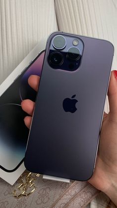 a person holding an iphone 11 in their hand next to a box with the phone on it