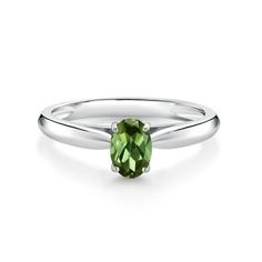 a white gold ring with an oval green stone