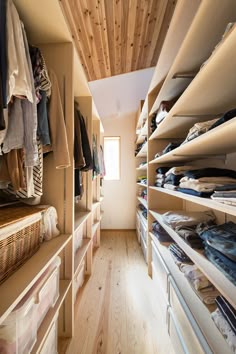 the closet is full of clothes and other items in it, including shirts on shelves