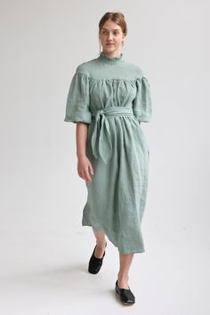 "Linen elegant dress with long wide sleeves, no shoulder line and delicate ruffle at the neck has tie detail in the back. Wide sleeves shrink with elastic at the bottom. Loose cut dress is comfy yet elegant and can be worn for various occasions. You can wear it without belt for romantic and free style or use belt to create more classic look. Belt is long enough to go around waist twice! For more chic look, style it with accessories. Double washed for extra softness and shrinkage prevention. ABOU Spring Prairie Dress With Gathered Sleeves For Garden Party, Chic Linen Dress With Gathered Sleeves, Summer Bishop Sleeve Dress For Brunch, Summer Brunch Dress With Bishop Sleeves, Linen Midi Maxi Dress With Ruffles, Elegant Spring Peasant Dress With Gathered Sleeves, Elegant Peasant Dress With Gathered Sleeves For Spring, Fitted Dresses With Ruffled Collar For Daywear, Fitted Linen Regency Dress